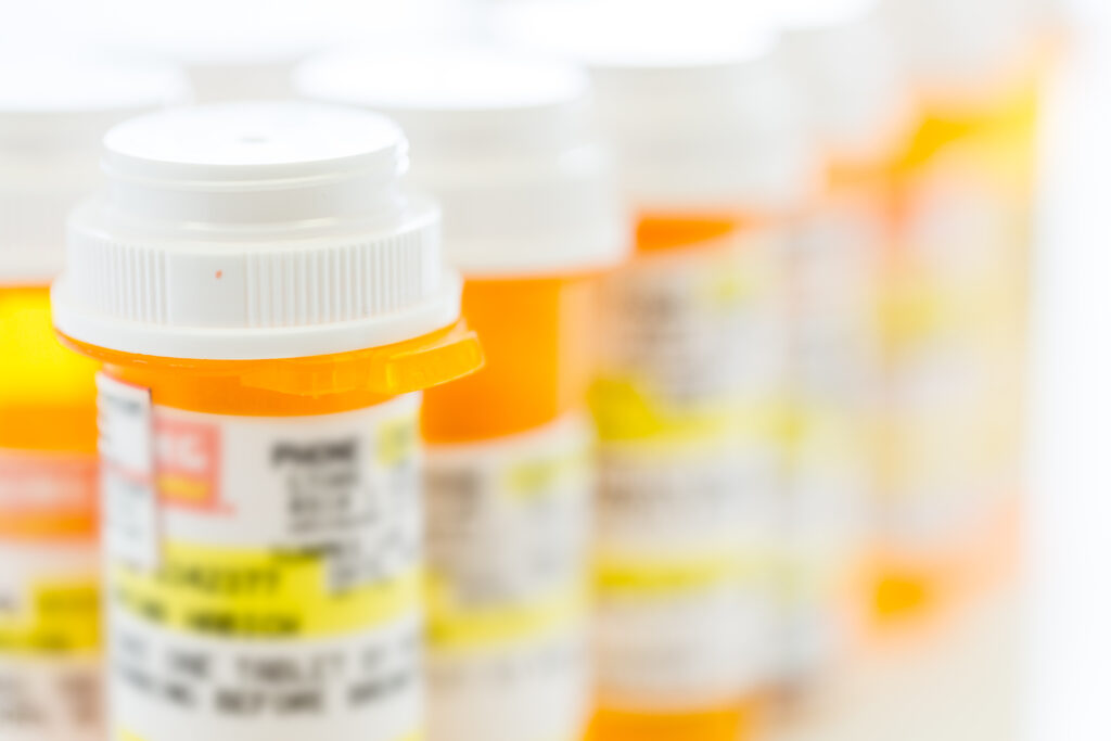 Prescription pills in yellow bottles on a white background.